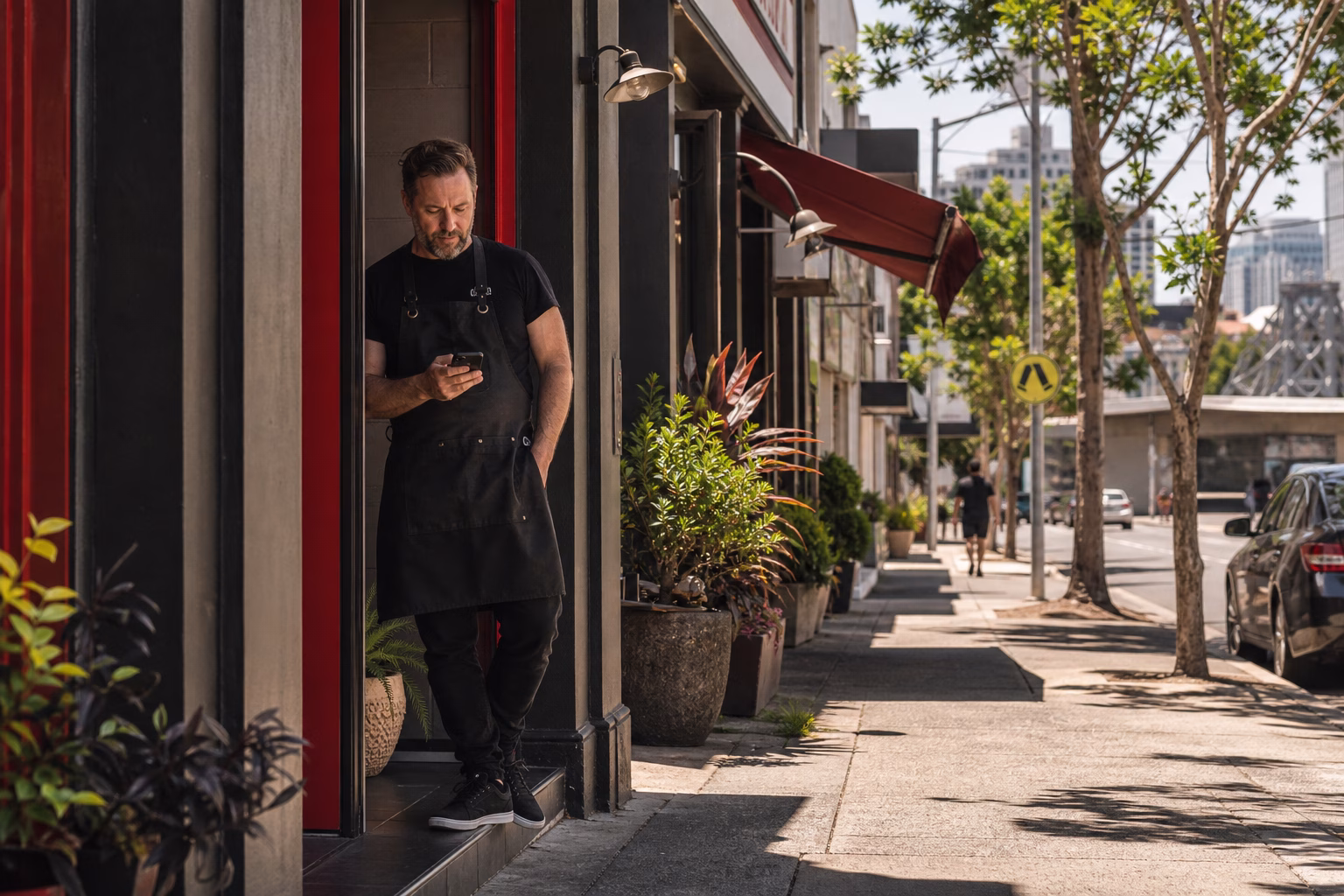 Australian business owner checking phone outside local office
